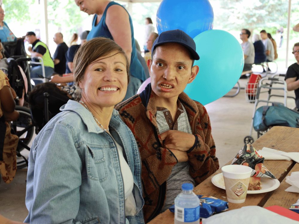 Woman and man sitting at a picnic table smiling