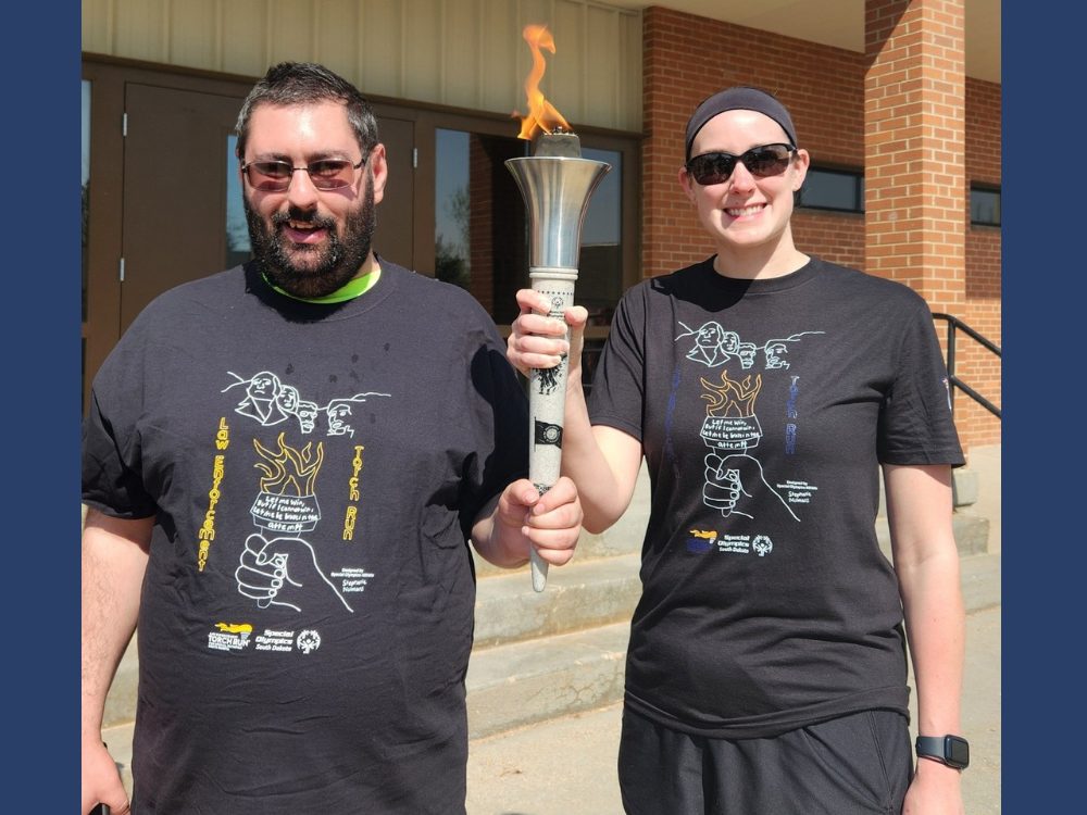 Two people holding the Special Olympics torch.